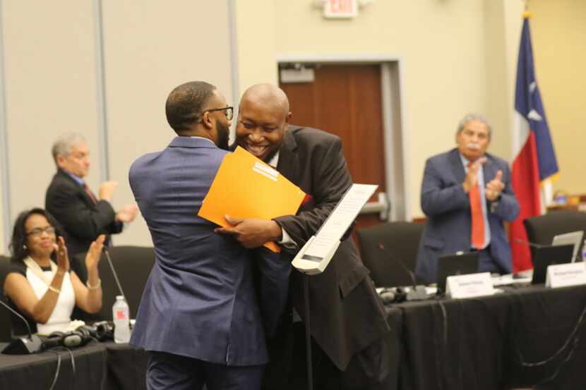 Dallas ISD trustee Maxie Johnson (right) hugged fellow trustee Justin Henry after being...