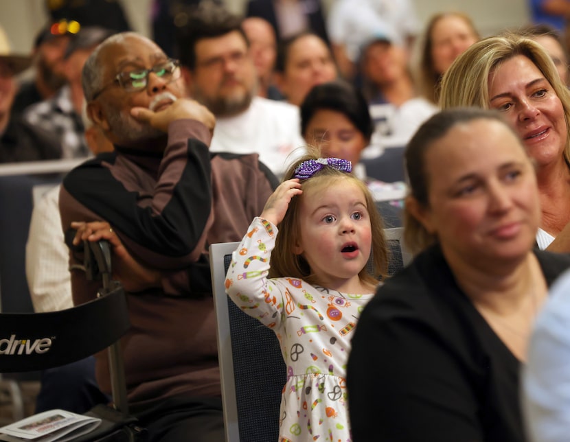 Willow Johnson, of Rockwall, lower center, reacts as she watches a video of service dogs in...