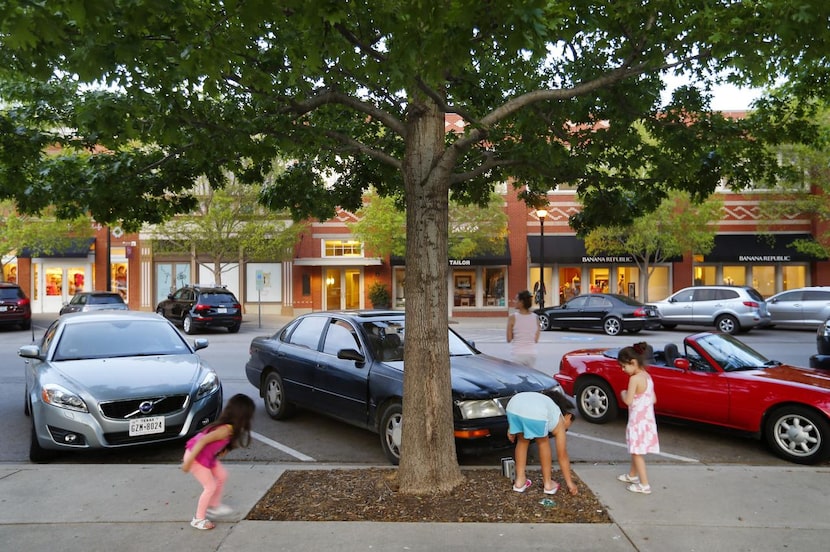 Niñas recolectan bellotas frente al cajón de estacionamiento de Southlake Town Square donde...