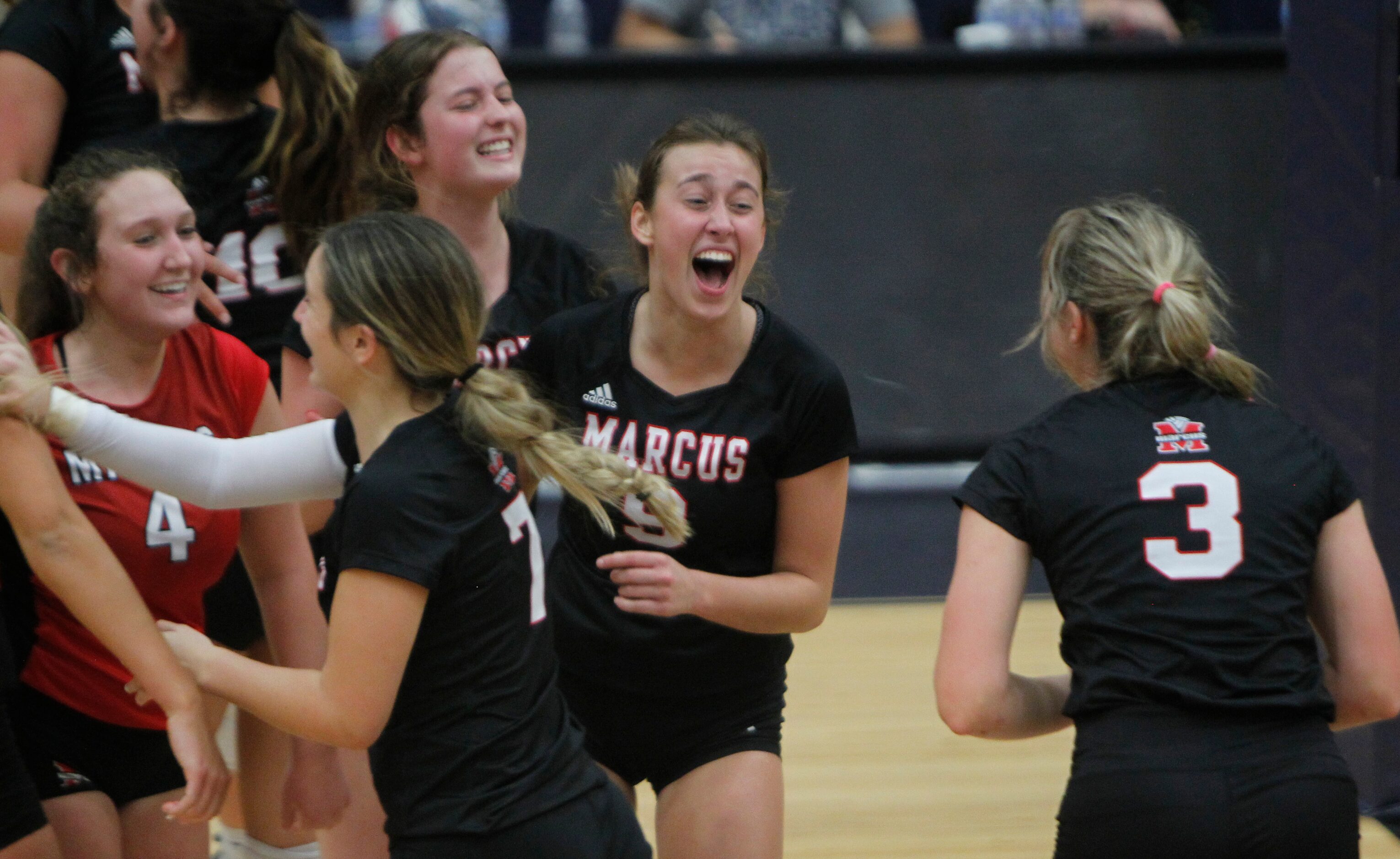 Flower Mound Marcus' Maggie Cox (9), center, was all smiles as she glances toward teammate...