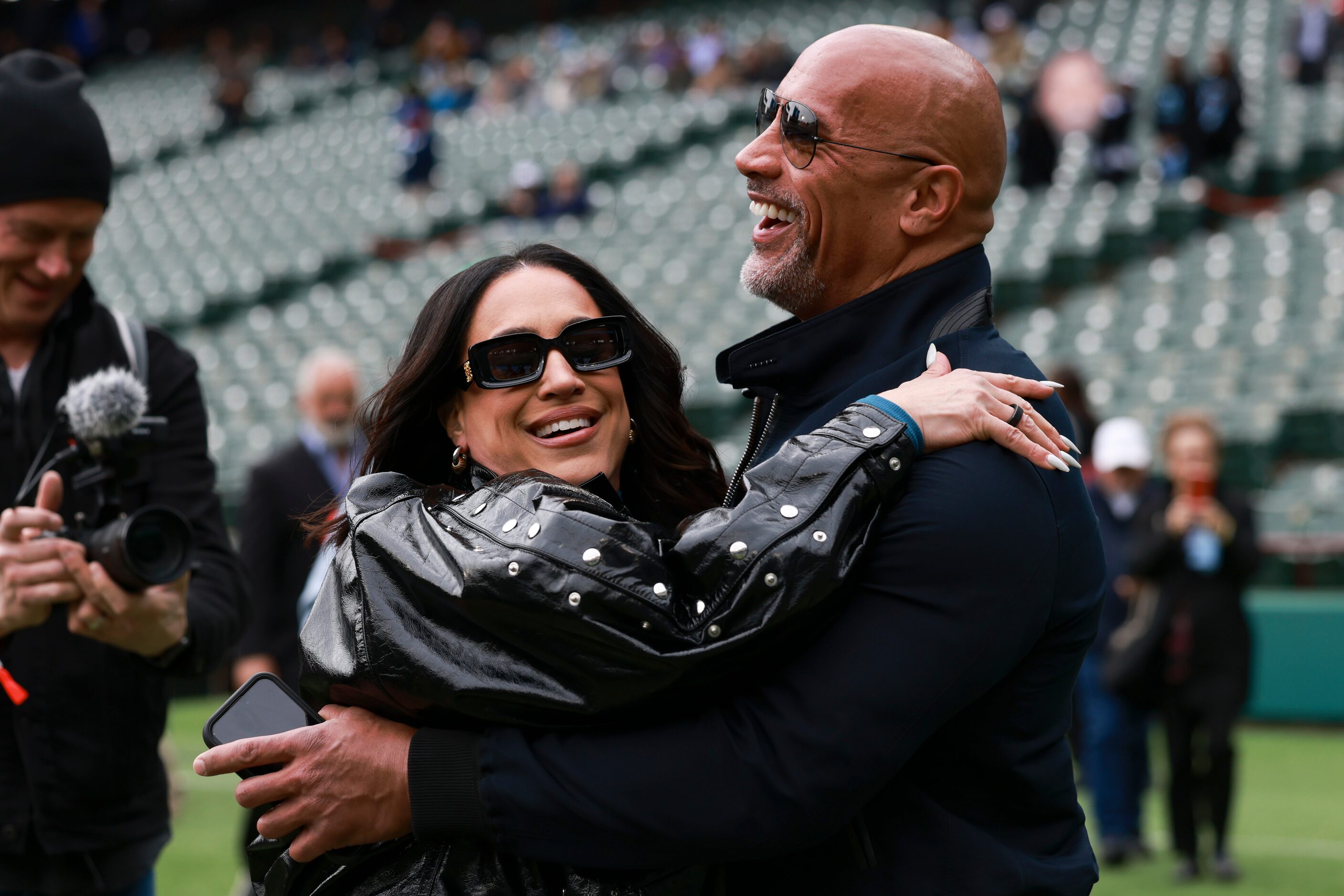 Dany Garcia runs into the arms of her husband, Dwayne “The Rock” Johnson, before an XFL...