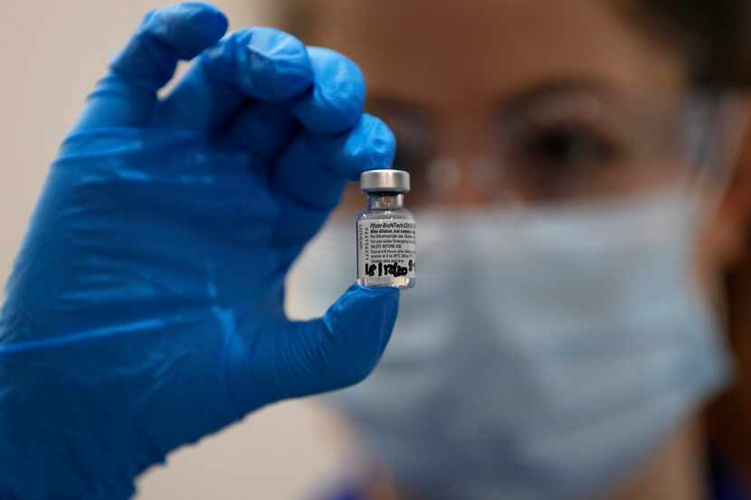 A nurse holds a vial of the Pfizer-BioNTech COVID-19 vaccine at a hospital in London....