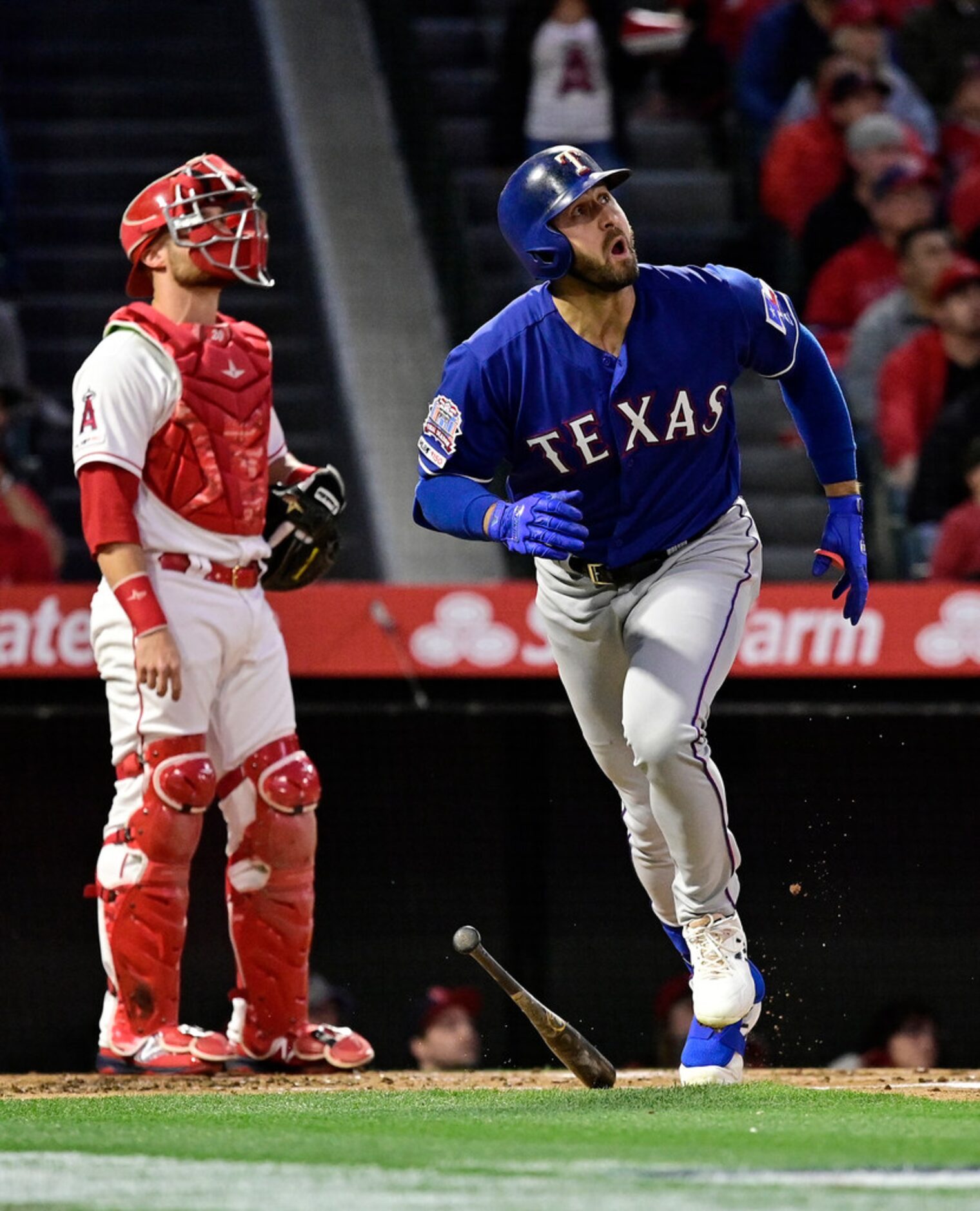 Texas Rangers' Joey Gallo heads to first on a three-run home run, next to Los Angeles Angels...