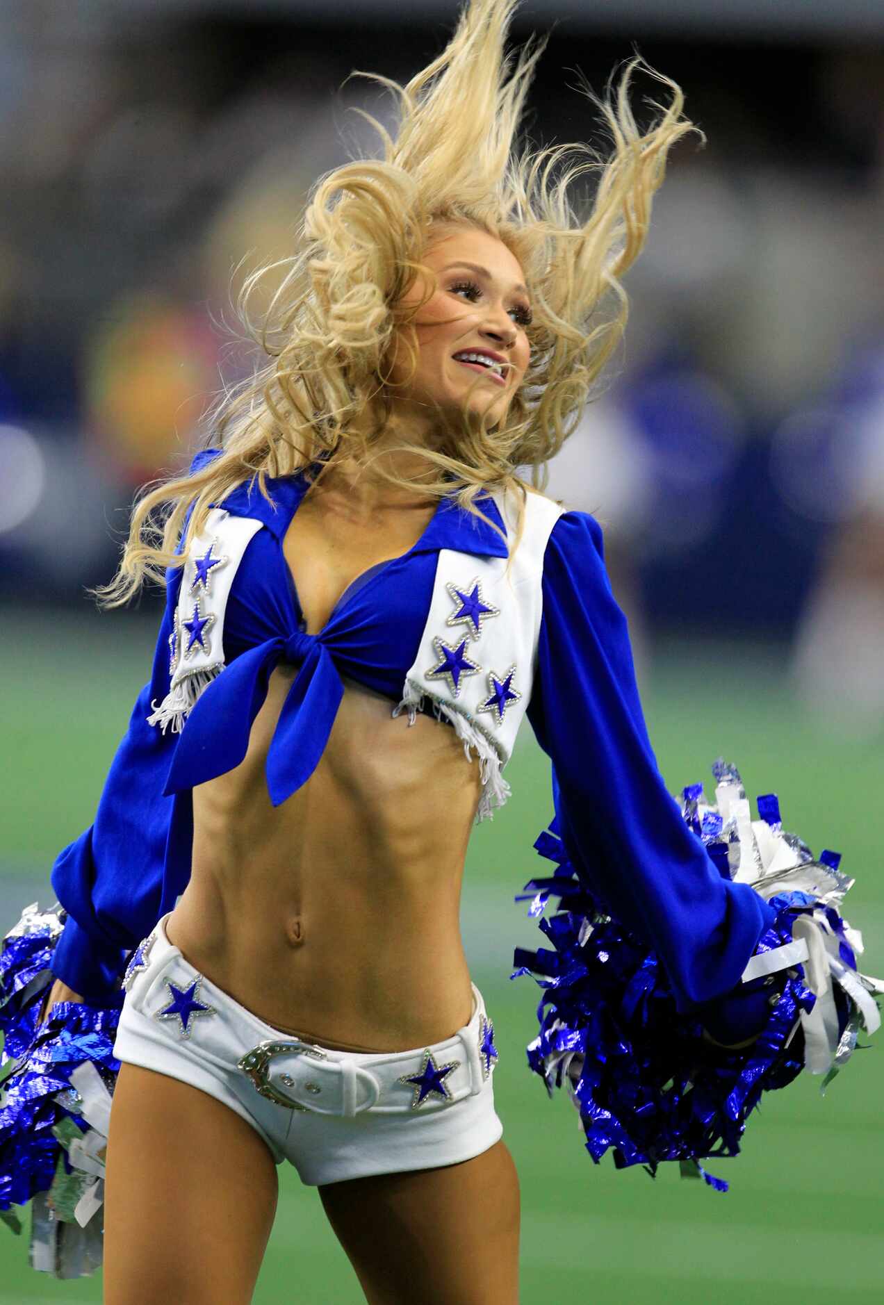 The hair of a Dallas Cowboy cheerleader flies in the air during a routine during a break in...