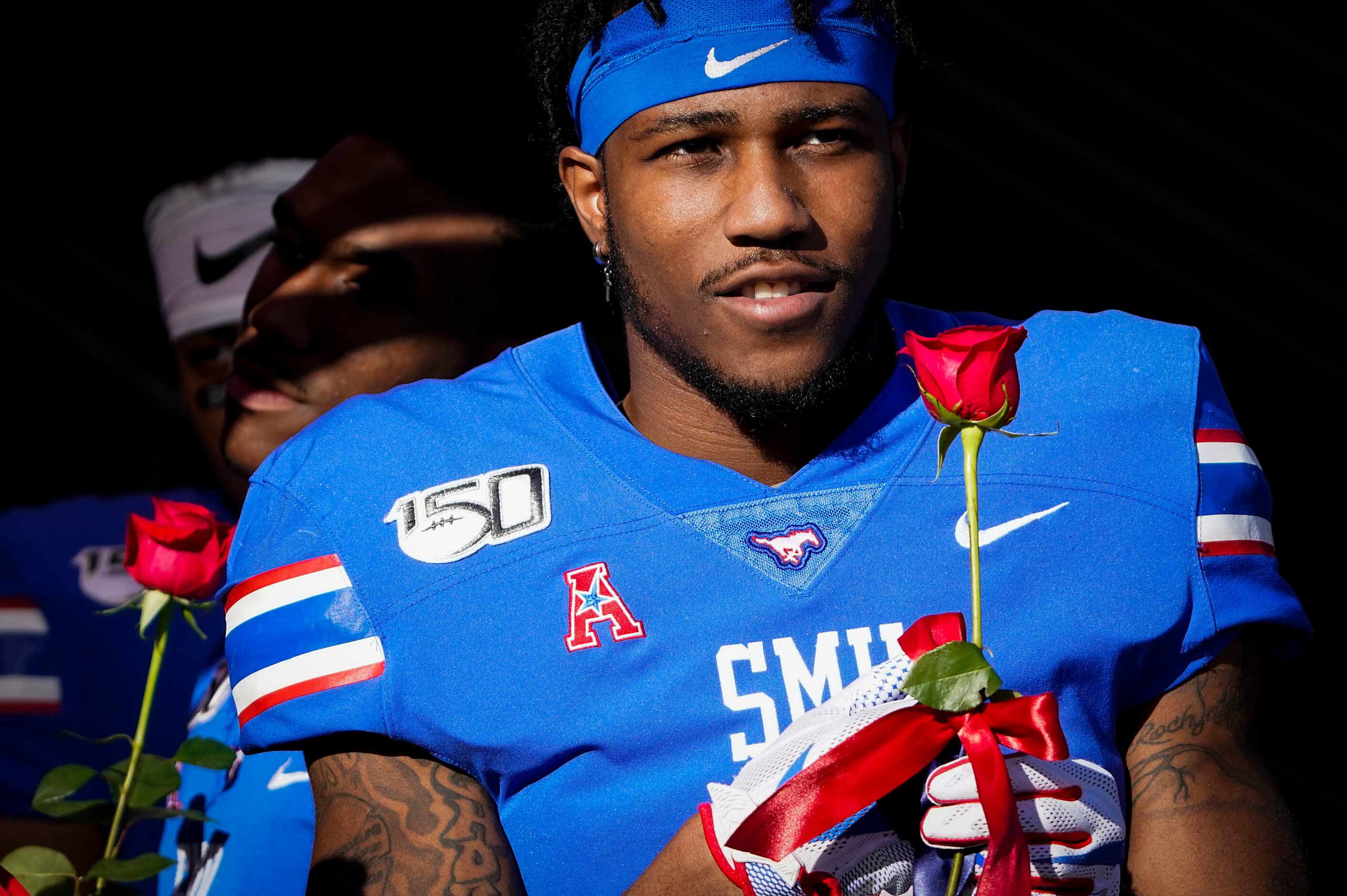 SMU cornerback Robert Hayes Jr. carries a rose onto the field during senior day activities...