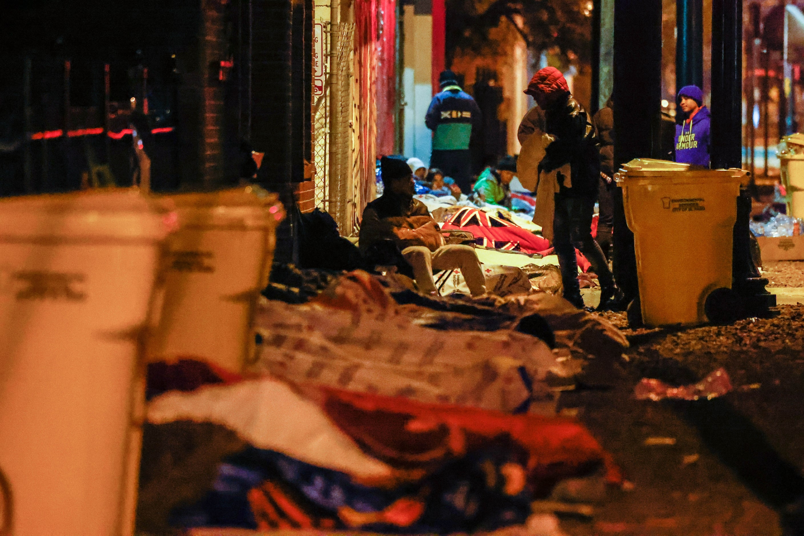 Migrants spend the night on the street at the Centro Pastoral Sagrado Corazon in El Paso on...