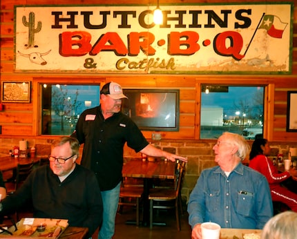 Trey Hutchins (standing) talks with customer Paul Fuller of Dallas in front of the original...