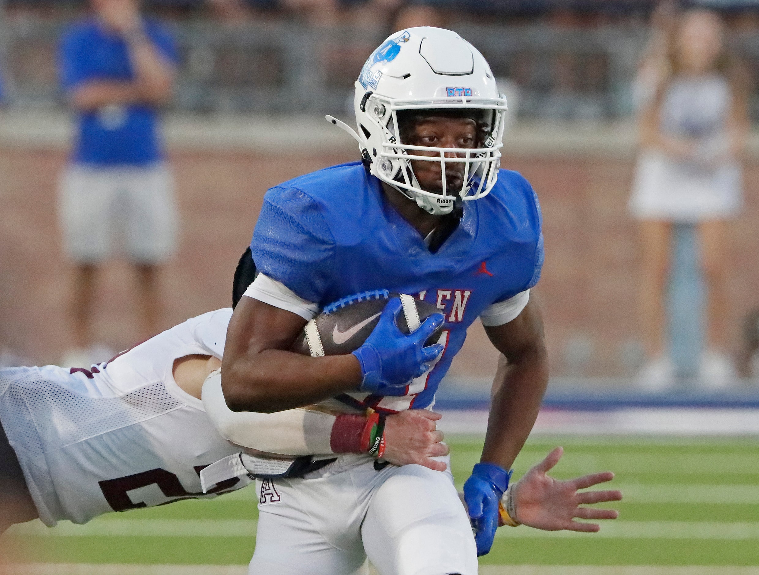 Allen High School running back Lyndon Spriggs (11) eludes a tackle during the first half as...