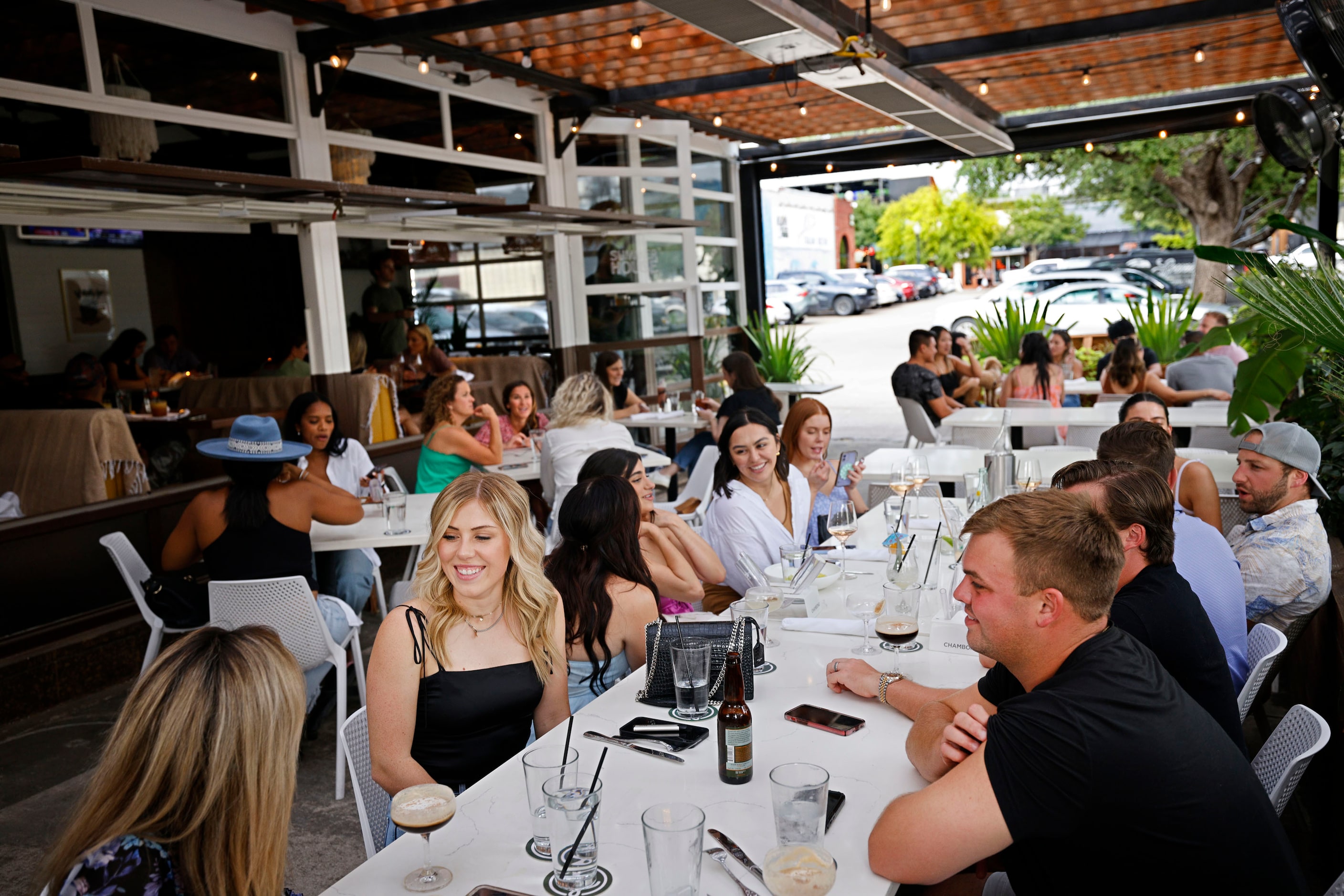 People enjoy dinner sitting on the patio at Leela’s Pizza and Wine in the Lower Greenville...