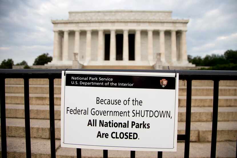 A sign reading "Because of the Federal Government SHUTDOWN All National Parks are Closed" is...