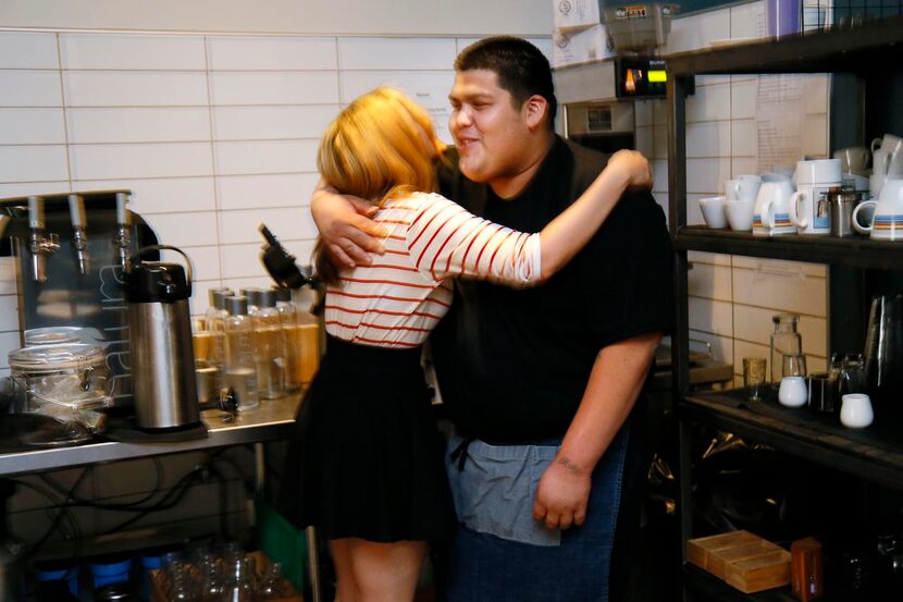 
Host manager Keisha Whaley (left) hugs intern Thomas Guandique as they start their evening...