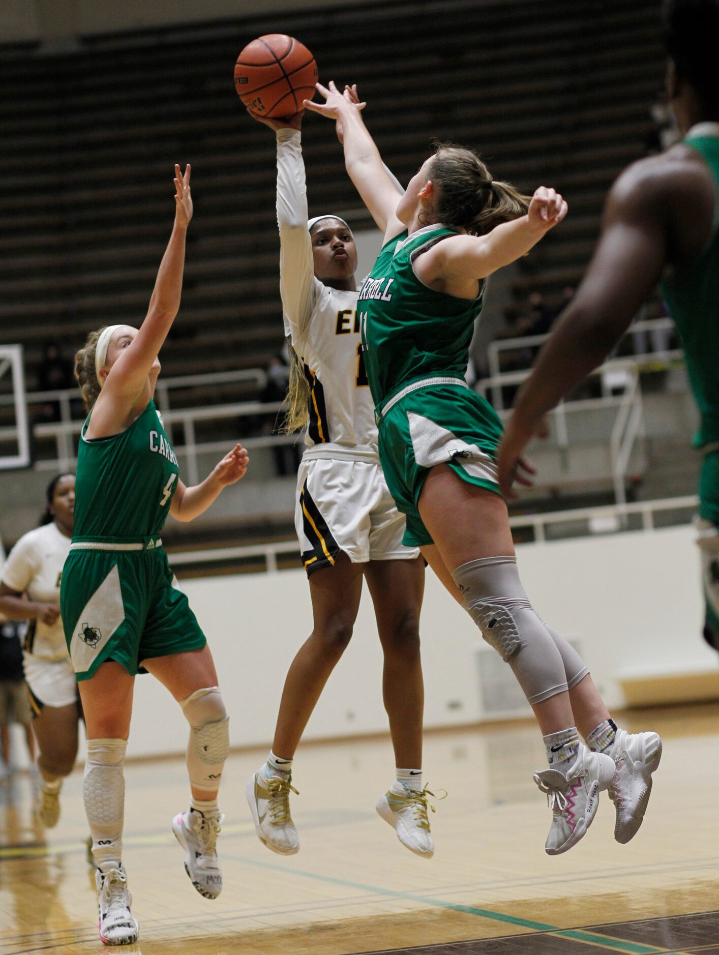 Plano East guard Kayla Cooper (11) puts up a jump shot between the defense of Southlake...