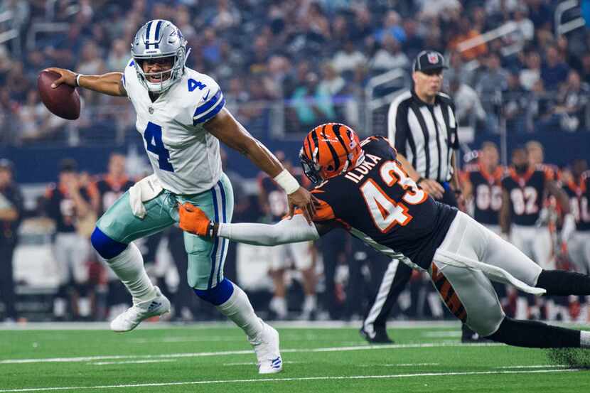 Dallas Cowboys quarterback Dak Prescott (4) escapes a tackle attempt by Cincinnati Bengals...