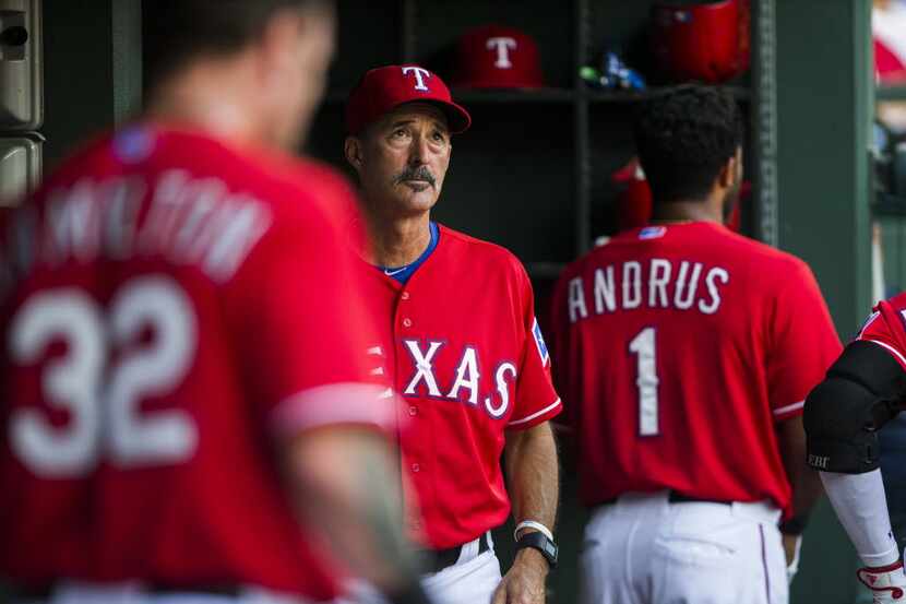 Texas Rangers pitching coach Mike Maddux (31) looks up at the score board from the dugout...