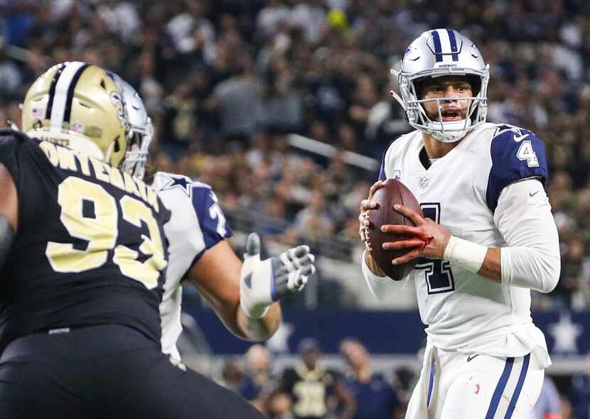 Dallas Cowboys quarterback Dak Prescott (4) looks to make make a pass as his hand is...