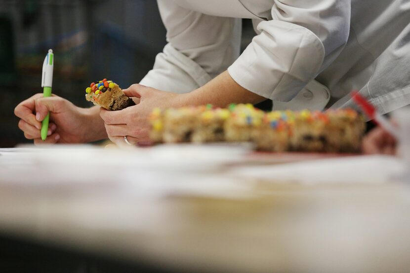 A judge takes notes on a cookie while judging the 22nd annual The Dallas Morning...