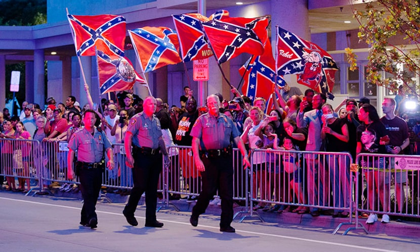  Demonstrators with Confederate battle flags greet President Barack Obama's motorcade as it...