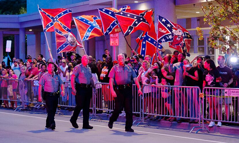  Demonstrators with Confederate battle flags greet President Barack Obama's motorcade as it...