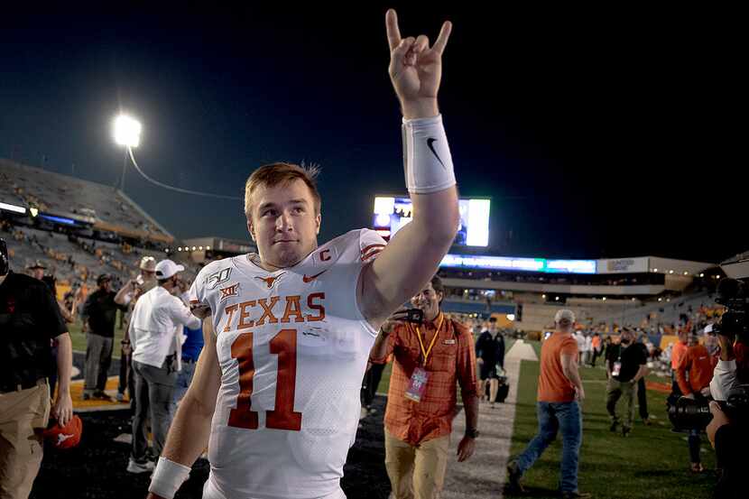 Texas quarterback Sam Ehlinger (11) holds up the "Hook 'Em Horns" gesture to fans after...