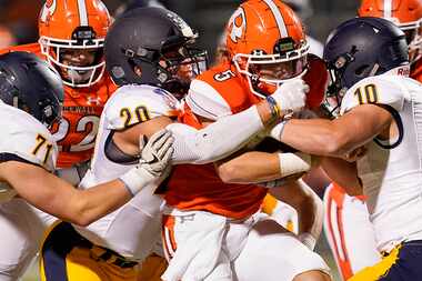 Rockwall quarterback Lake Bennett (5) is brought down by Highland Park’s Patrick Turner (20)...