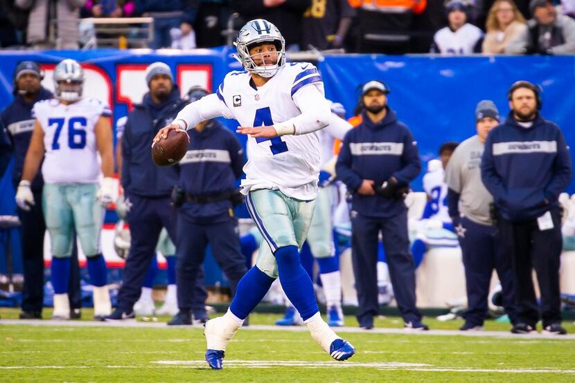 FILE - Cowboys quarterback Dak Prescott (4) scrambles to throw a 32-yard touchdown pass to...
