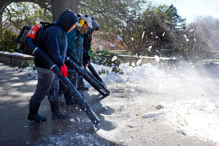 
Dallas Arboretum workers used their leaf blowers to clear snow from walkways on Thursday....