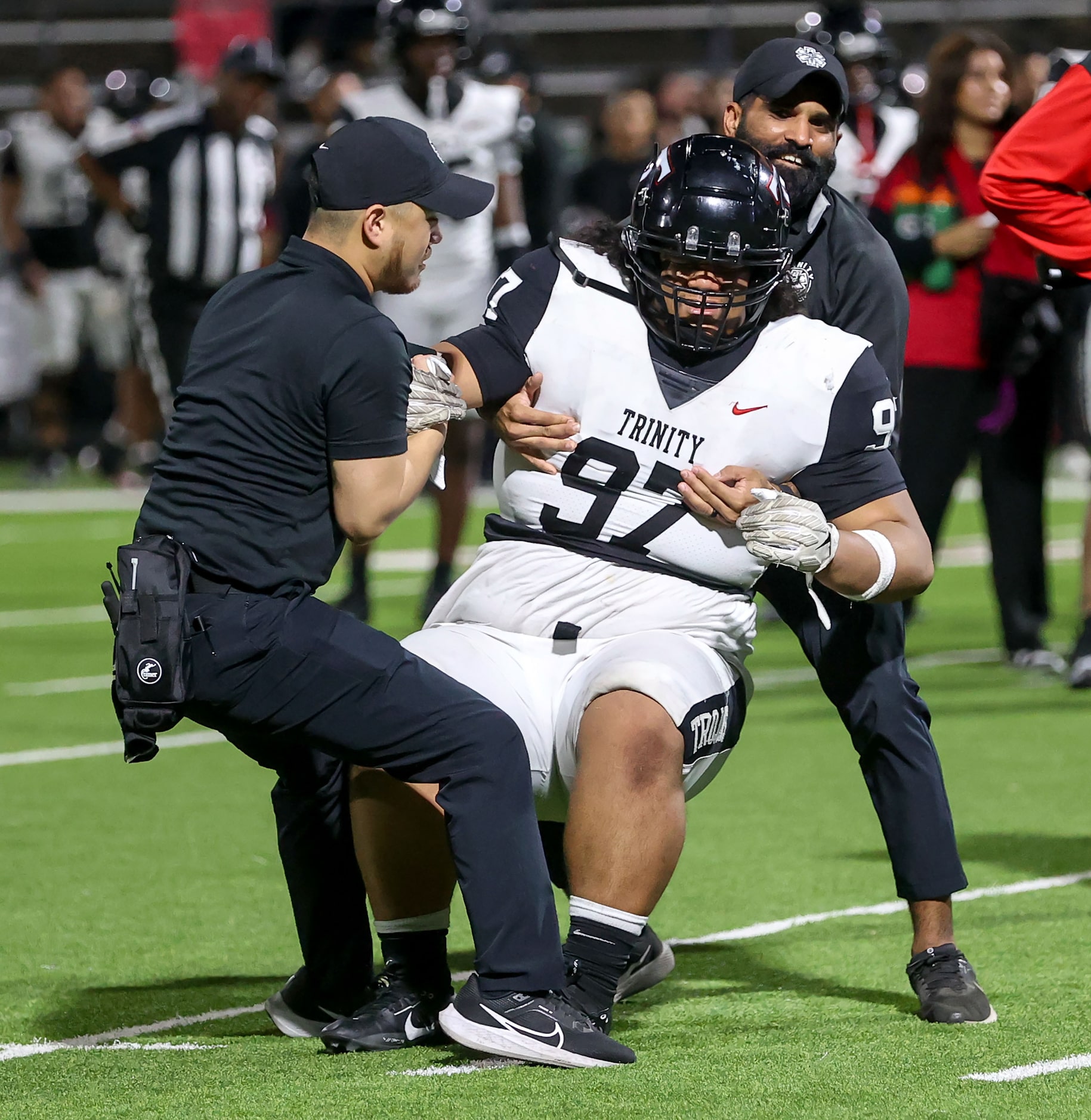 Trinity defensive lineman Koni Latu is helped up after getting injuried against Justin...