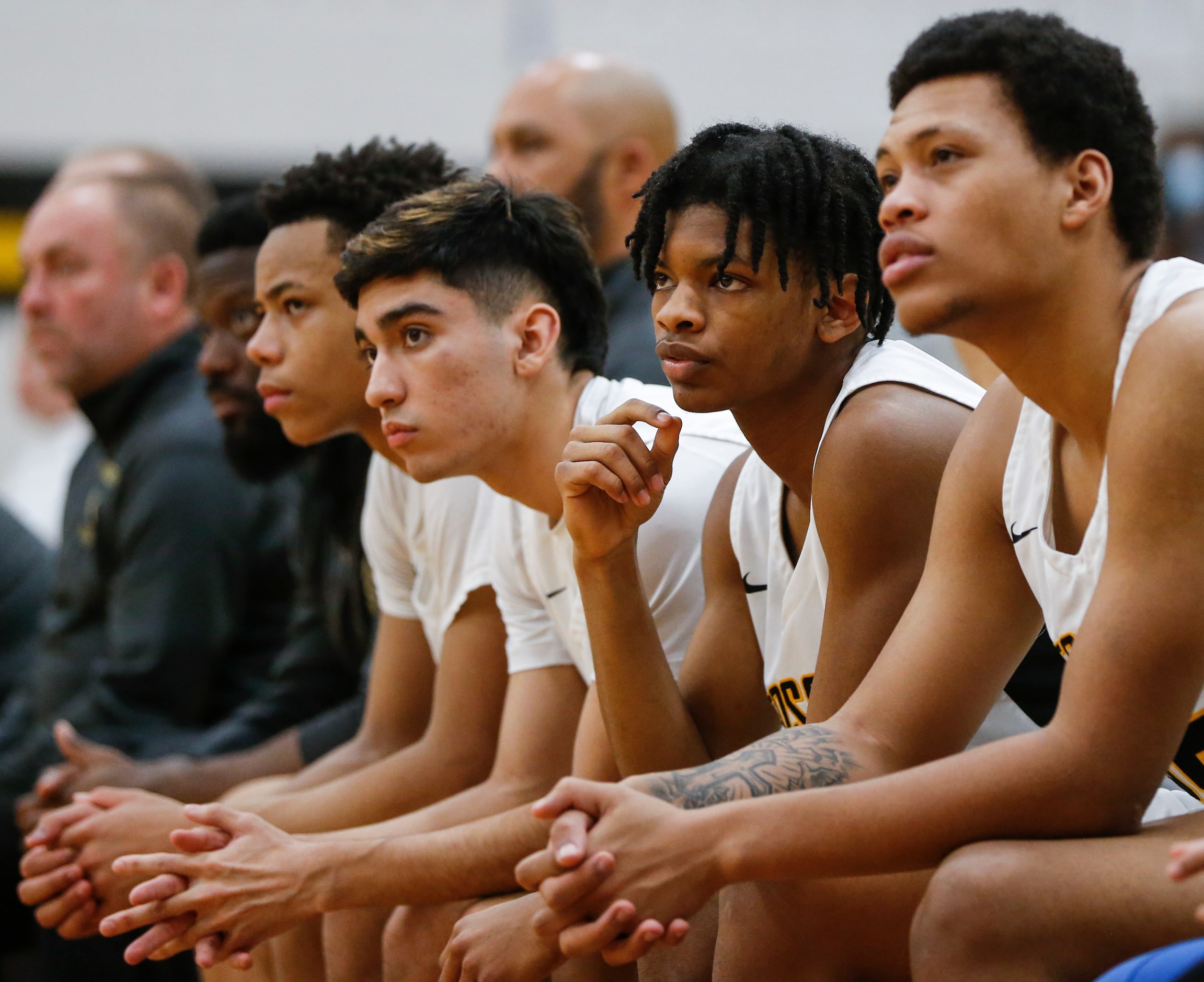 Fossil Ridge High School players watch as their teammate shoots a free-throw during the...