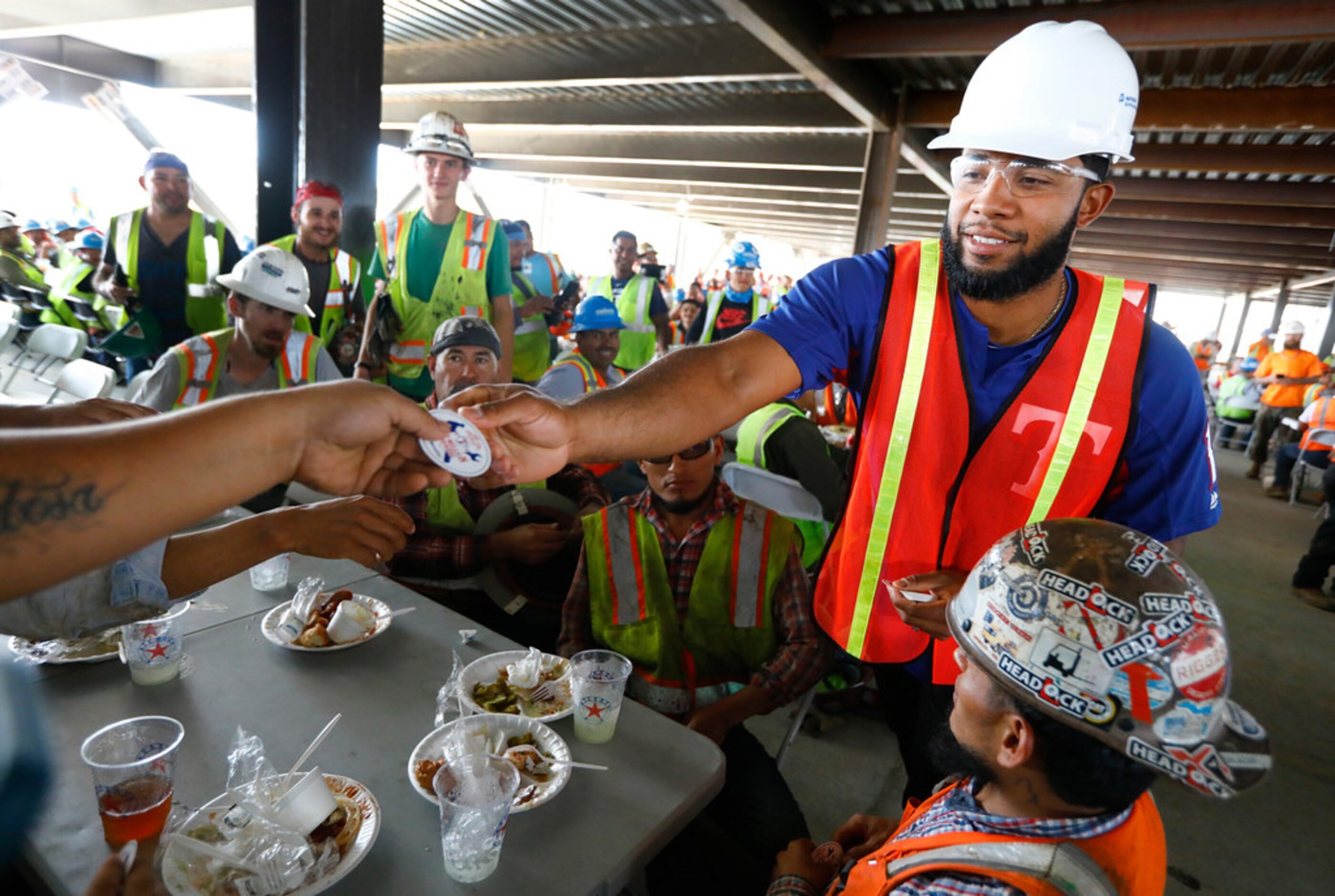 Texas Rangers shortstop Elvis Andrus hands out One Million Man Hours helmet stickers to...