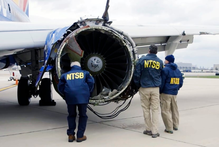 Investigators in Philadelphia examine the damaged engine that caused the death of a...
