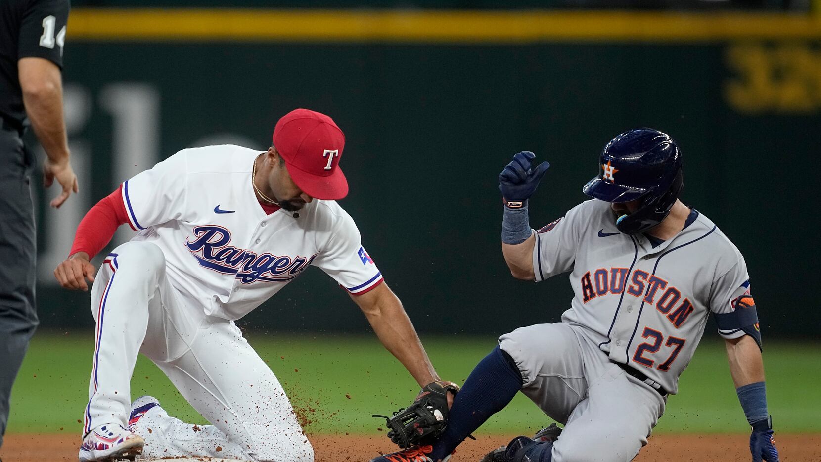 Texas Rangers second baseman Marcus Semien, left, tags out Houston Astros' Jose Altuve (27)...