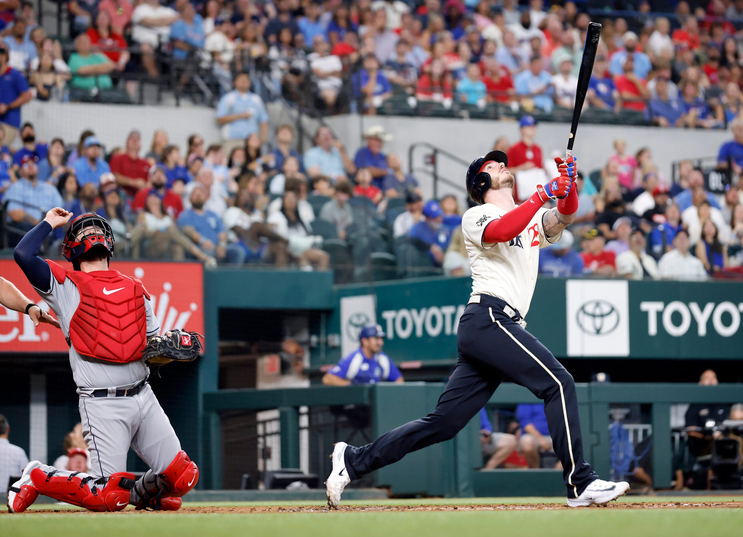 Texas Rangers batter Jonah Heim (28) and Cleveland Guardians catcher Cam Gallagher (35) look...