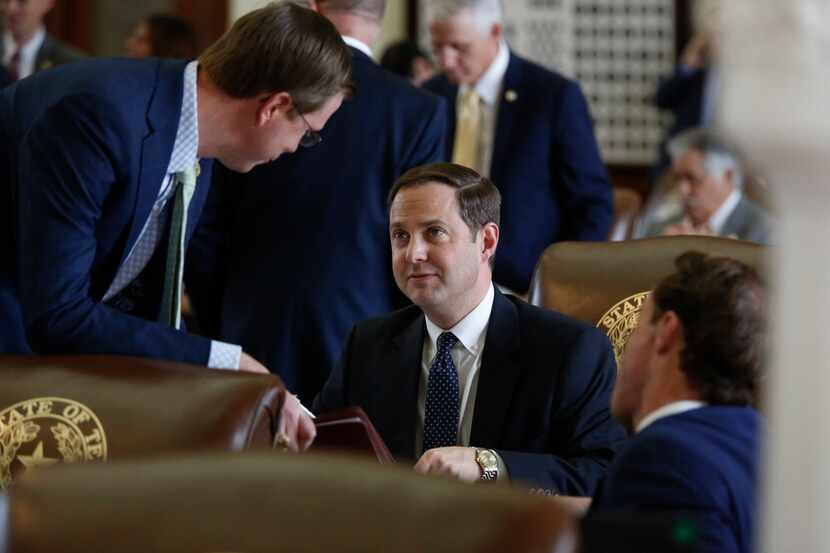  Rep. Dustin Burrows, R-Lubbock, center, shown on the House floor in April, has resigned as...