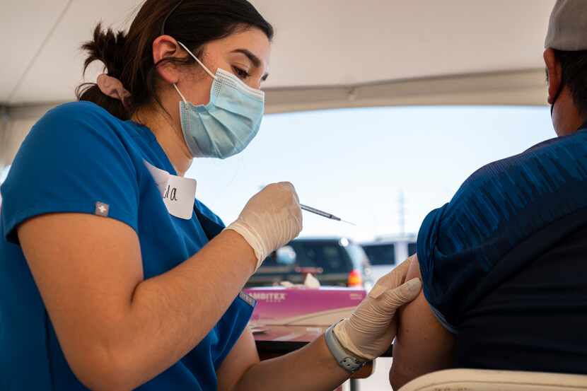 Registered nurse Pamela Ayala administers a Pfizer vaccine to a Latino man during a pop-up...