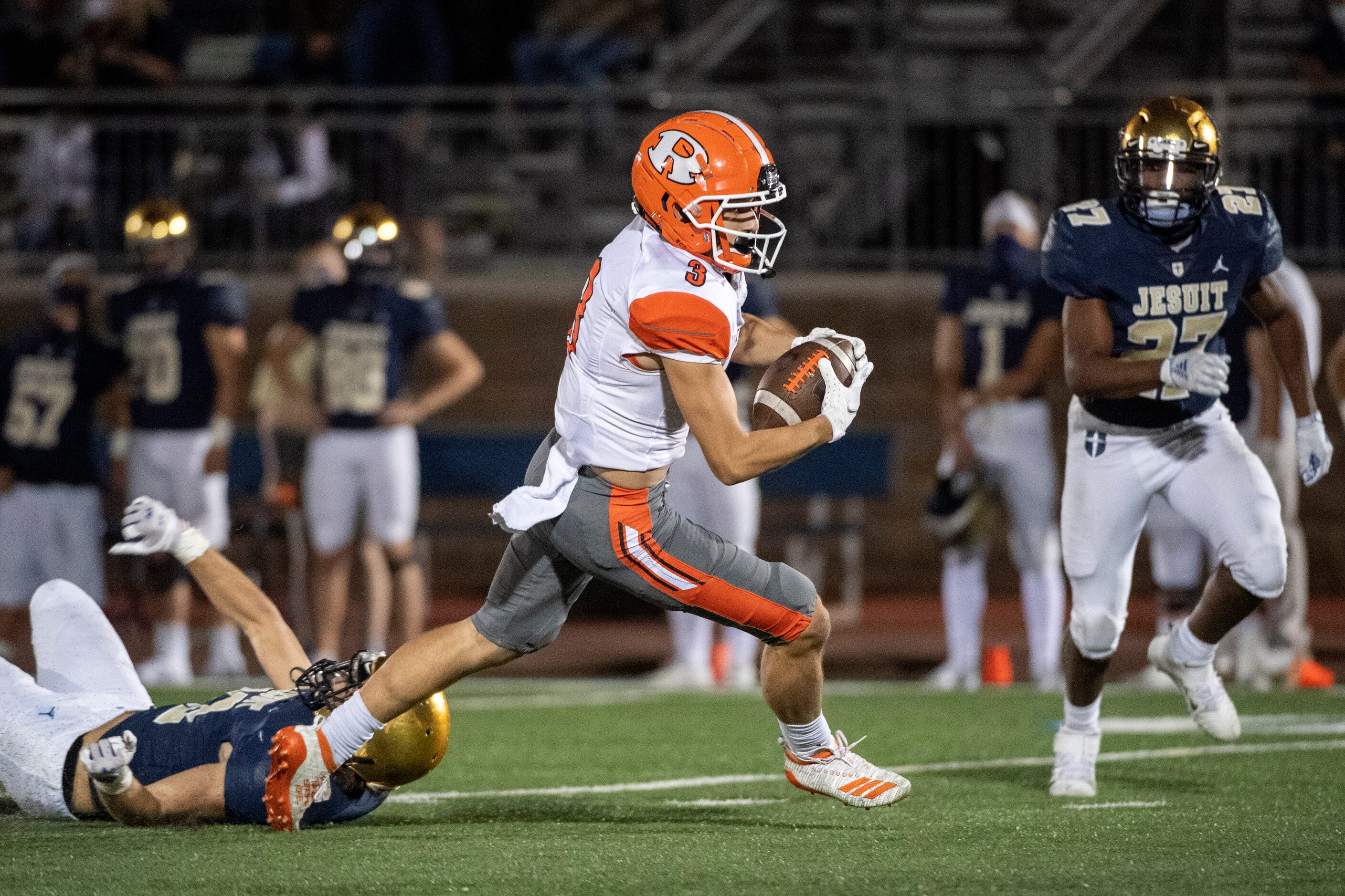 Rockwall senior wide receiver Jax Johnson (3) races past Jesuit junior defensive back Brady...