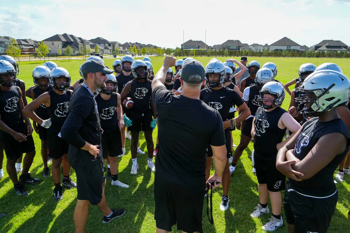 Players huddle around head coach Clint Surratt during the first day of football practice for...