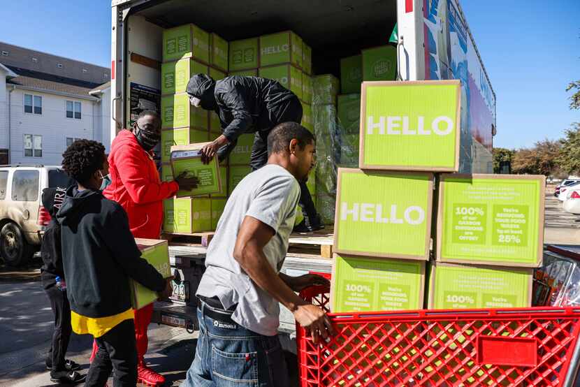 Volunteers haul boxes of food into Lakewest Senior Housing near Singleton Boulevard and...