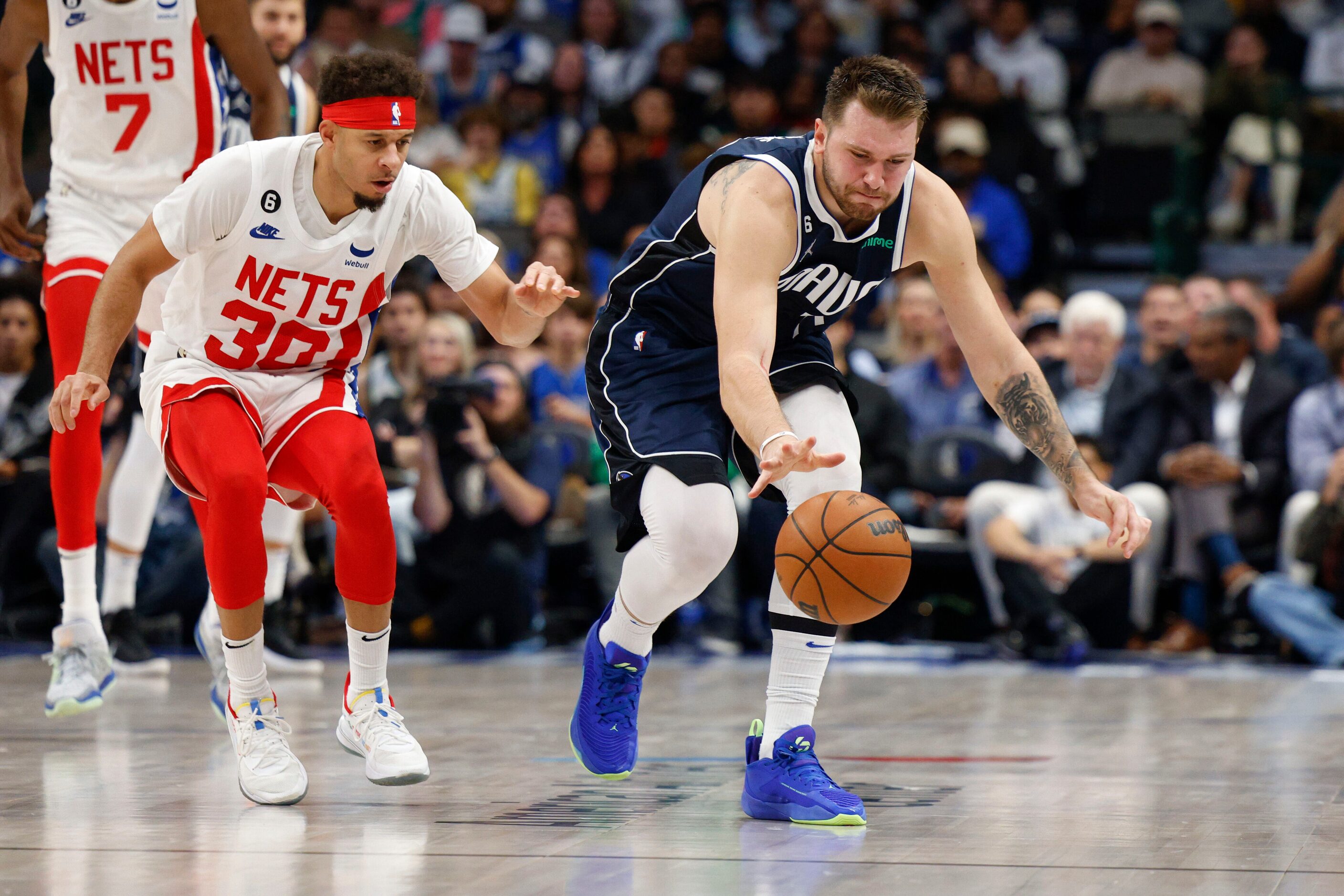 Dallas Mavericks guard Luka Doncic (77) reaches for a loose ball ahead of Brooklyn Nets...