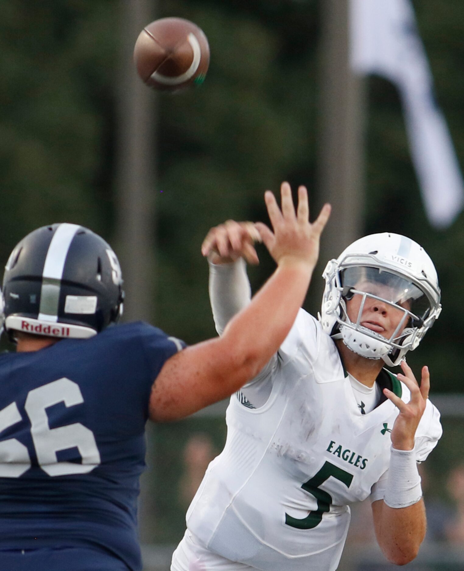 Prosper quarterback Jackson Berry (5) launches a long pass downfield over the pursuit of...