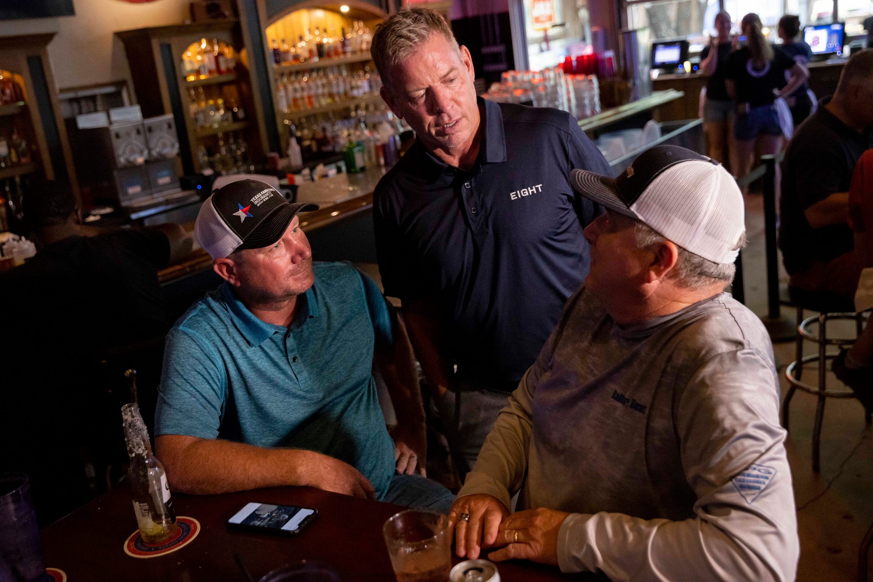 Chris Reynolds (left) and Bruce Miller (right) chat with former Cowboys quarterback Troy...