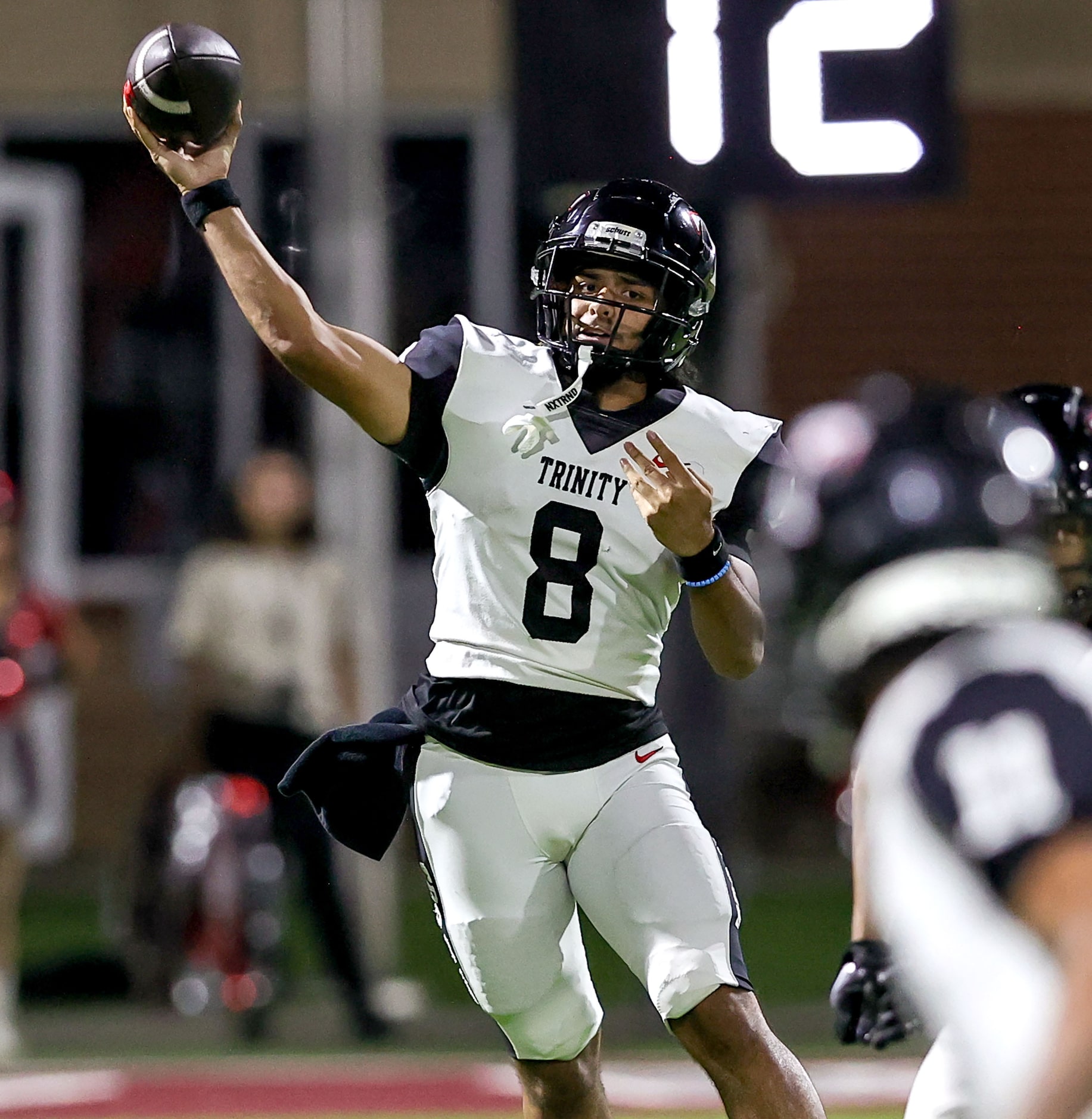 Trinity quarterback TJ Tupou tries to get a pass off to wide receiver Antwan McGee against...