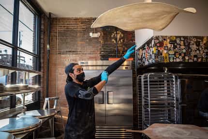 Restaurant manager Francisco Arrona tosses and stretches pizza dough at Serious Pizza in...