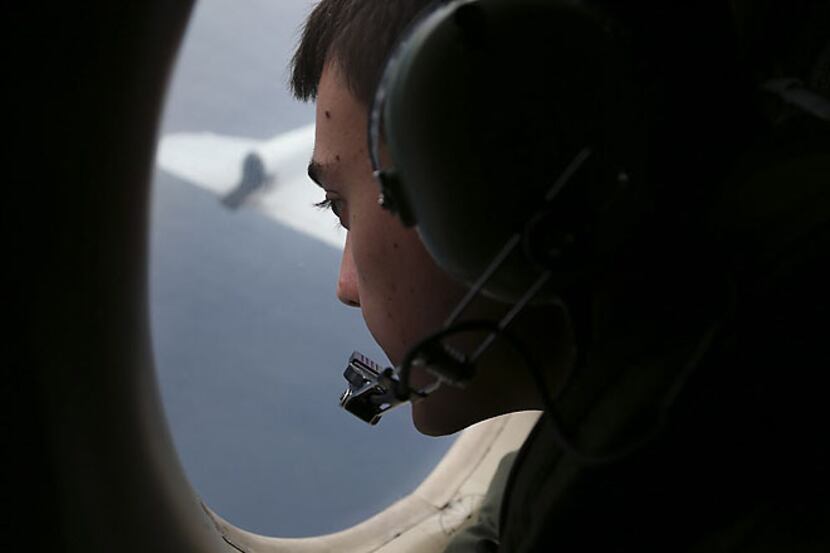 Royal Australian Air Force Sgt. Matthew Falanga scans the southern Indian Ocean from the...