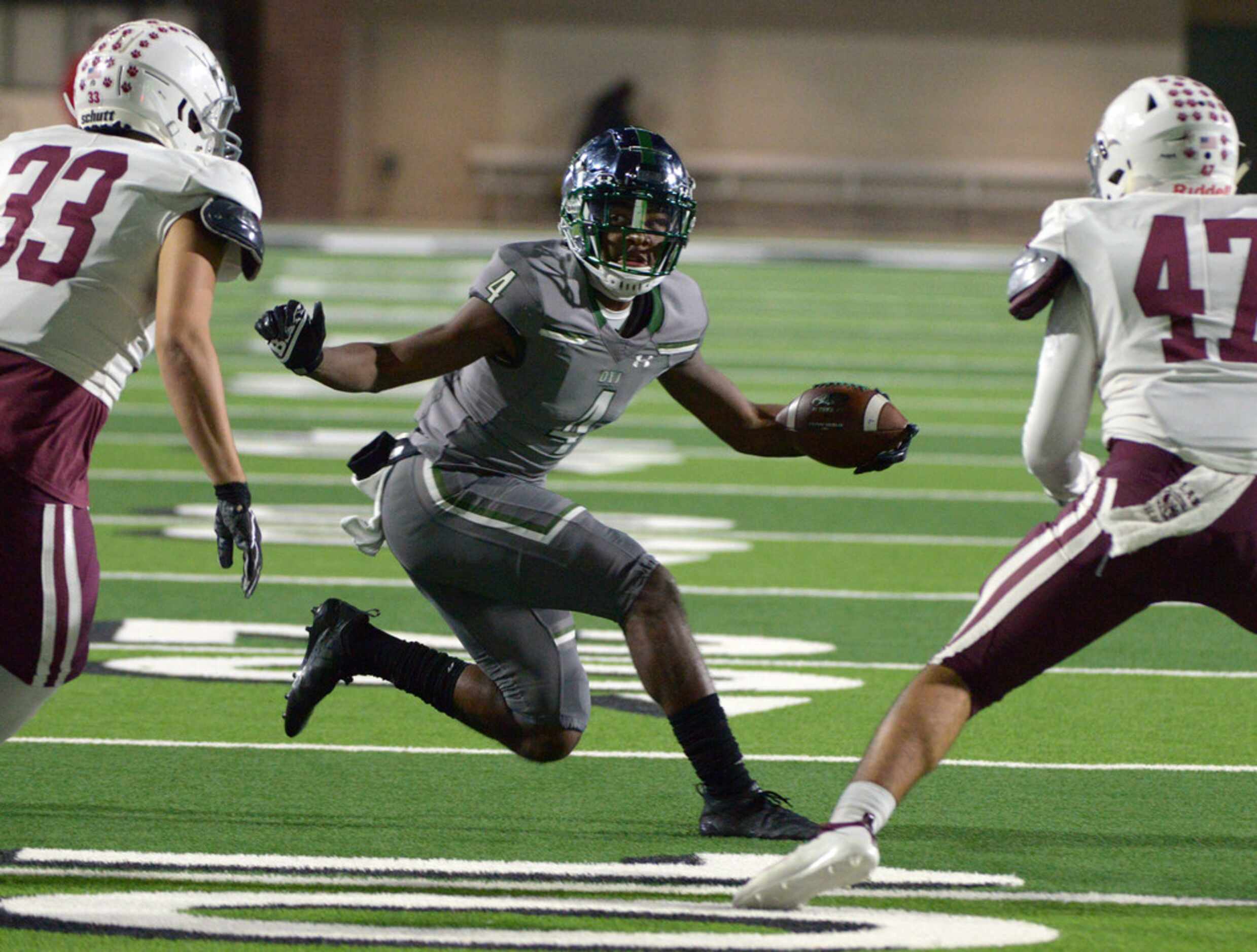 Prosper's Tyler Berry (4) looks for running room between Plano's Jonathan Ajdukovich (33)...