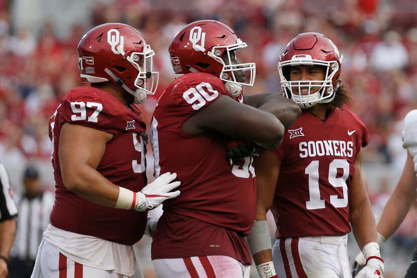 Oklahoma defensive tackle Neville Gallimore (90) celebrates with teammates Marquise Overton...