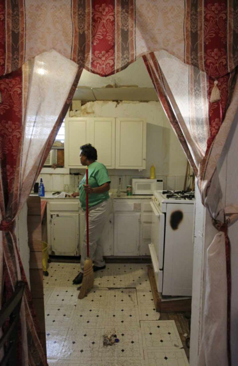 Brenda Shanks sweeps dust from the tiny kitchen of the Liberty in Christ House of God...