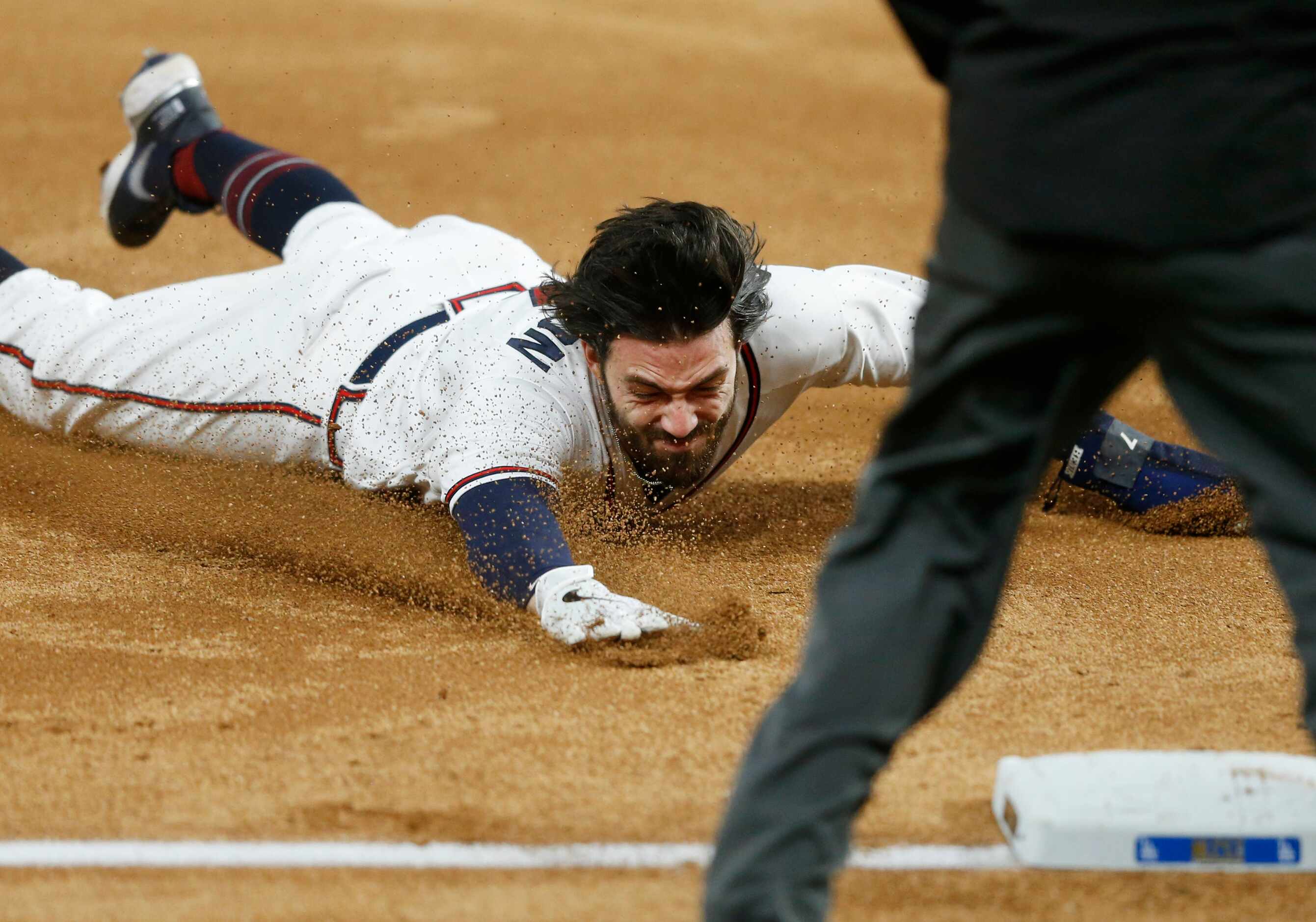 Atlanta Braves shortstop Dansby Swanson (7) sfaely dives for third base off a hit from...