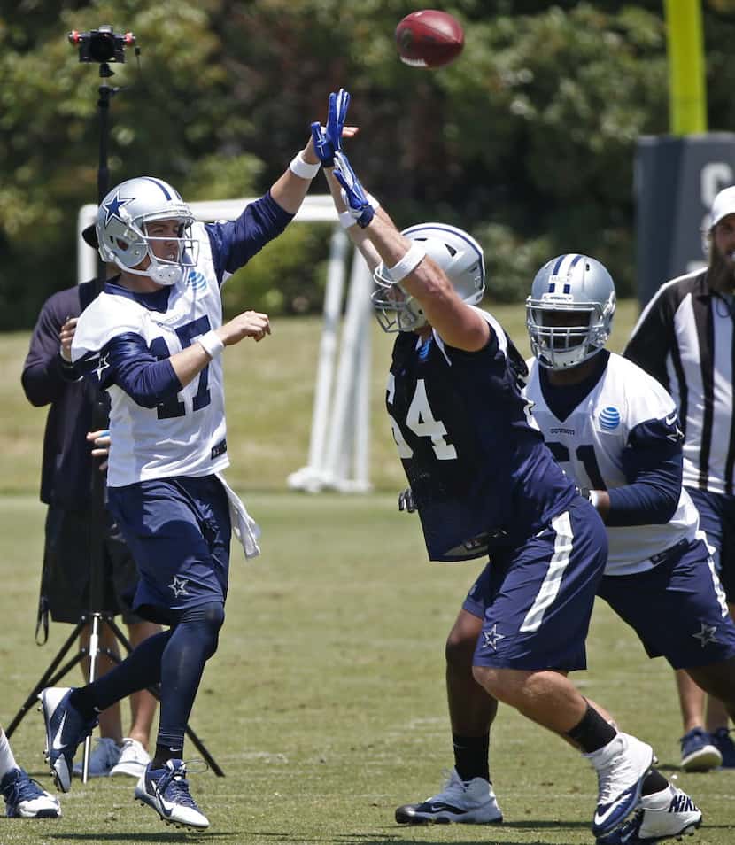 Dallas Cowboys Kellen Moore throws the ball over Zach Wood during OTA practice at Valley...