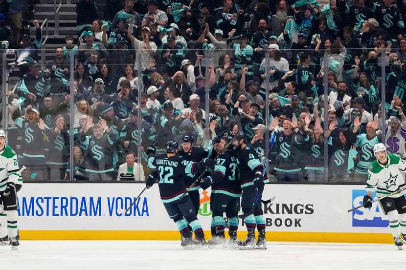 The Seattle Kraken celebrate a goal by right wing Eeli Tolvanen as Dallas Stars defenseman...