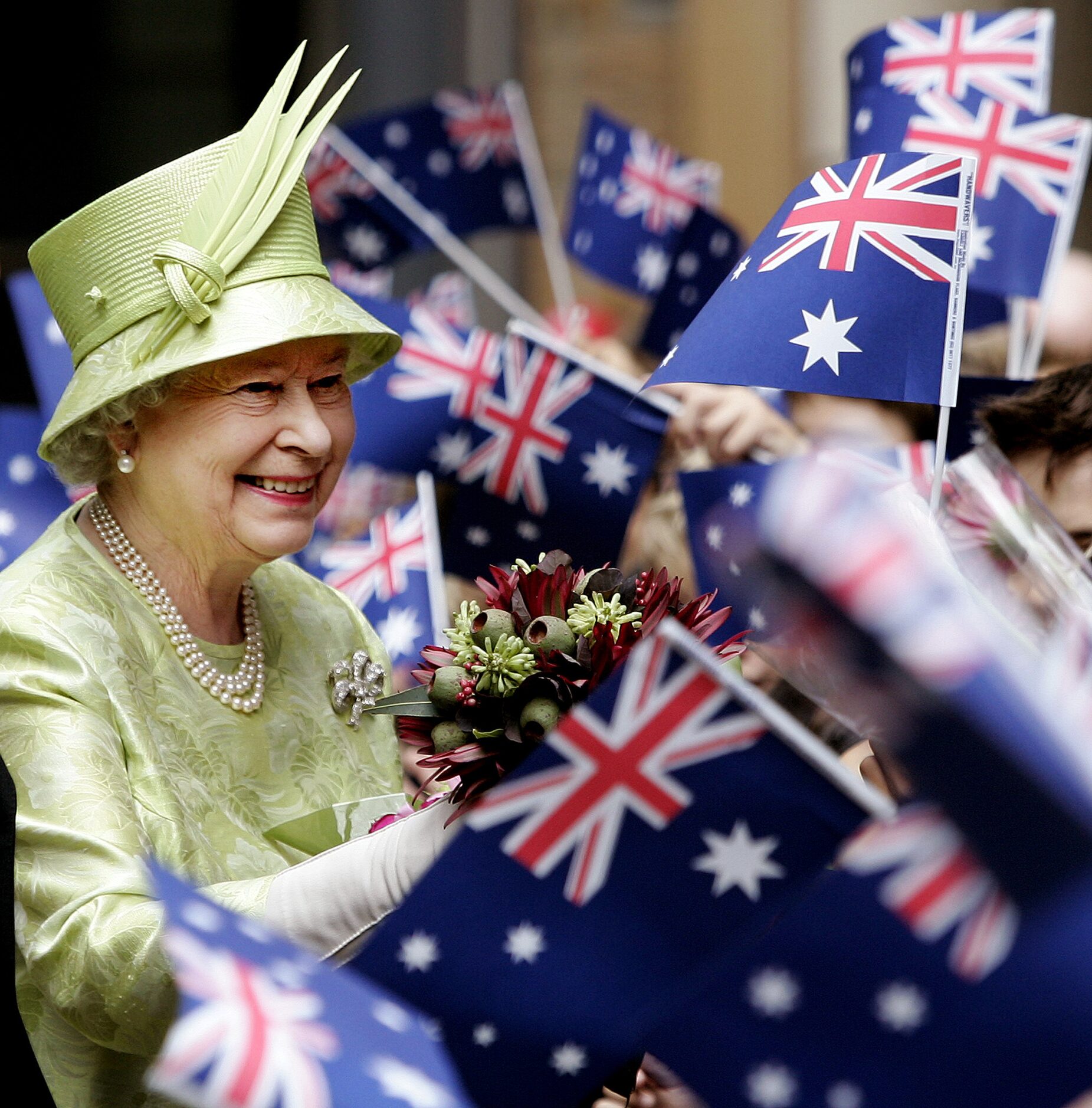 Britain's Queen Elizabeth ll,  left, receives flowers from waiting school childrenwith...